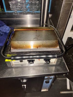 un grill surmonté d'une poêle, dans une cuisine