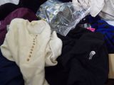 a pile of clothes that is sitting on top of a bed