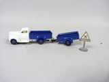 un camion miniature sur lequel est accrochée une pancarte à l'arrière