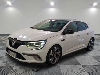 Une voiture blanche est garée sur un sol en damier dans une pièce
