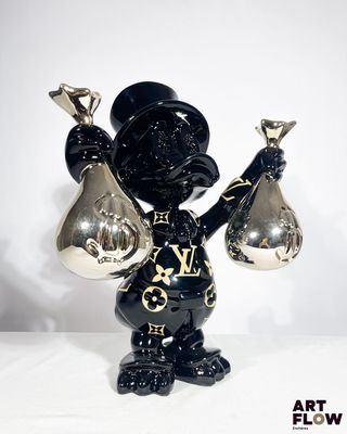une figurine noire et dorée représentant un homme tenant deux cloches