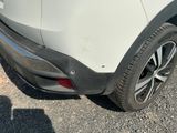 the rear end of a white car with black rims parked in a parking lot