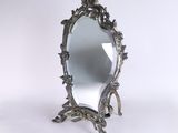 a mirror that is sitting on a stand on a white surface