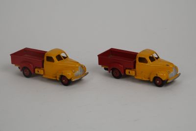 two toy trucks sitting next to each other on a white surface