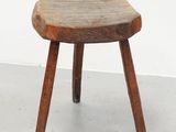 un vieux tabouret en bois posé sur un sol en béton