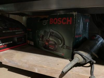 une boîte d'outils Bosch posée sur une étagère à côté d'une boîte d'outils électriques Bosch