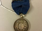 l'image d'une médaille ornée d'un ruban bleu sur un fond blanc