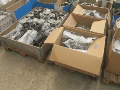 plusieurs cartons contenant des objets divers, posés à même le sol en béton