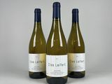 three bottles of wine sitting on top of a white table