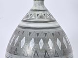 a black and white vase sitting on a white surface