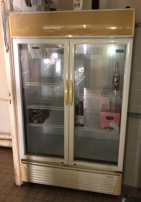 a refrigerator with two glass doors in a kitchen