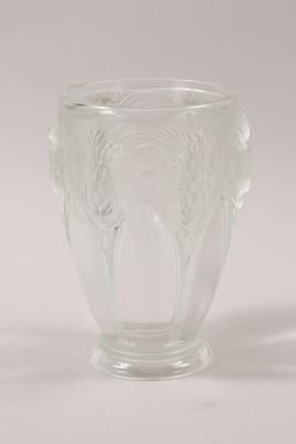 clear glass vase with two handles on a white surface