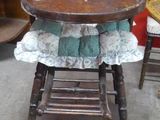a wooden high chair with a blue and white cloth on it