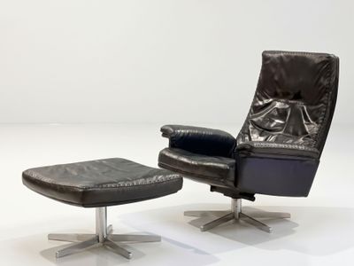 a black leather recliner chair and ottoman in a white room