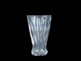 un vase en verre posé sur une surface noire