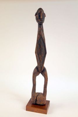 statue d'un homme debout sur un socle en bois, sur fond blanc