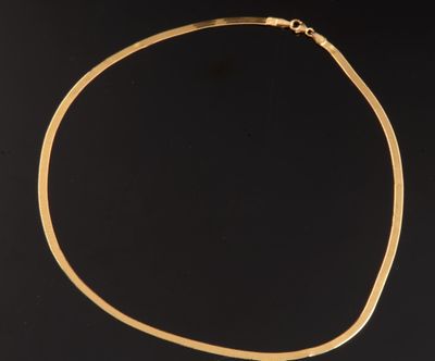 gros plan d'un collier en or sur fond noir