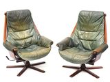 pair of green leather swive chairs with wooden legs and arms