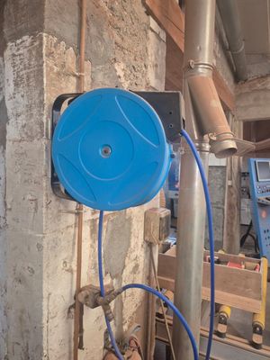un tuyau bleu fixé à un poteau métallique dans une pièce