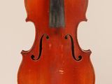 un vieux violon suspendu à une ficelle sur un mur blanc