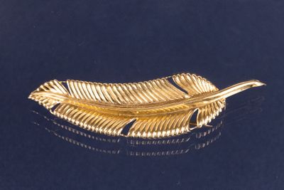 une broche en feuille d'or sur un fond noir