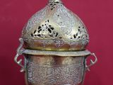 an antique silver plated bowl with a lid on a stand on a red background