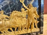 a statue of a man and a woman on a horse drawn carriage