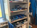 a shelf full of tools in a room with a blue wall