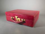 a red suitcase sitting on a gray surface