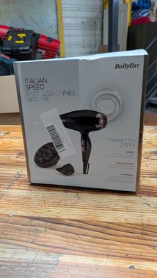 La boîte du sèche-cheveux est ouverte sur la table.