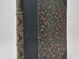 un livre noir aux bords dorés et à la couverture verte