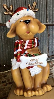 a statue of a dog wearing a santa hat and holding a sign