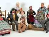 many figurines of people sitting on a bench