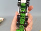 a person holding a green toy truck in their hand