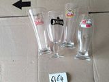 three empty beer glasses sitting on the floor next to a cardboard box