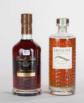 deux bouteilles de rhum et une bouteille de rhum vide posées sur une surface blanche