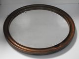 un miroir rond avec un cadre en bois posé sur un support blanc