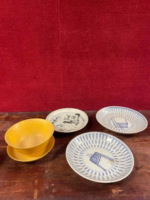 quatre assiettes et un bol posés sur une table avec un fond rouge