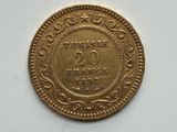 a close up of a gold coin on a white surface