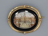 a picture of a black and gold broochle with a picture of a palace