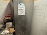 une photo d'un réfrigérateur dans une cuisine très encombrée