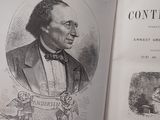 a person holding an open book with a picture of a man in a suit