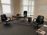une photo d'un bureau vide avec un bureau et des chaises