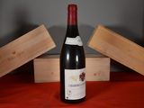 a bottle of wine sitting on a table next to two wooden boxes