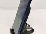 a close up of a cell phone on a stand on a white surface