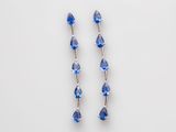 une paire de boucles d'oreilles en cristal bleu sur fond blanc