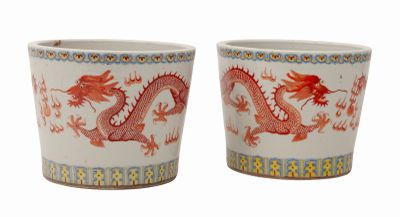 une paire de tasses rouges et blanches ornées de motifs représentant des dragons