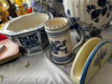 many vases and cups on a table with flowers