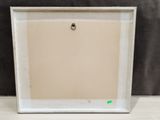 an empty picture frame with a green sticker on it