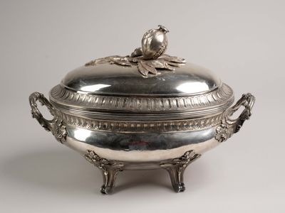 an antique silver plate covered with a bird on top of it